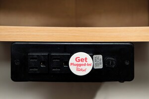 Un enchufe eléctrico negro con una tarjeta blanca que dice '¡Conéctate! RedRoof'.