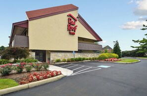 A Red Roof Inn with a parking lot and a stone facade. - Red Roof Inn Louisville East - Hurstbourne (Louisville)