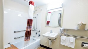 Un baño con bañera, ducha, lavabo y secador de manos.