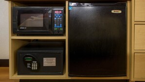 A kitchen with a microwave, a digital clock, and a refrigerator. - Red Roof Inn Louisville East - Hurstbourne (Louisville)