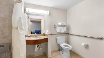 Une salle de bain équipée d’un lavabo, d’un miroir, de toilettes et d’un rideau de douche.