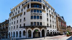 Un hotel de varios pisos con una fachada curva, ventanas amplias y una entrada central con dosel.