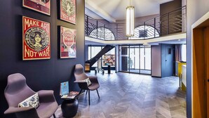 Un hall espacioso con muebles modernos, una escalera y obras de arte en las paredes.