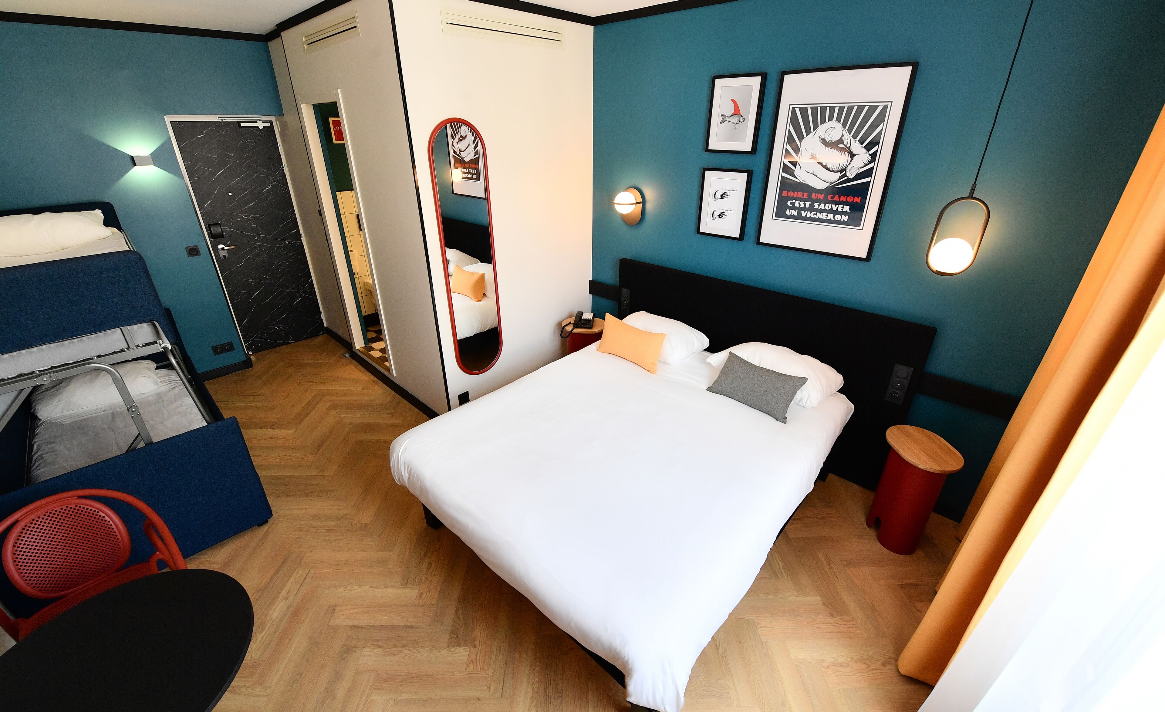 Habitació d'hotel amb llit, escriptori, cadira i armari.