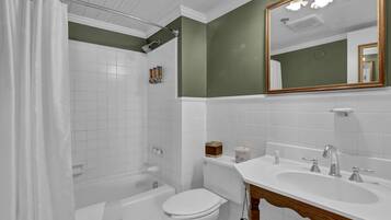 Un baño con bañera, inodoro y lavamanos.