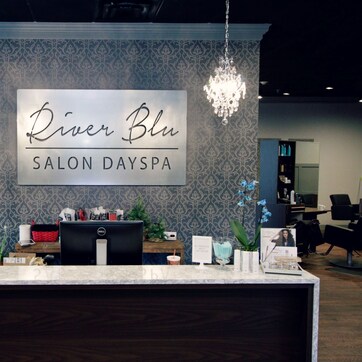 A salon reception area with a sign reading "River Blu Salon Dayspa".