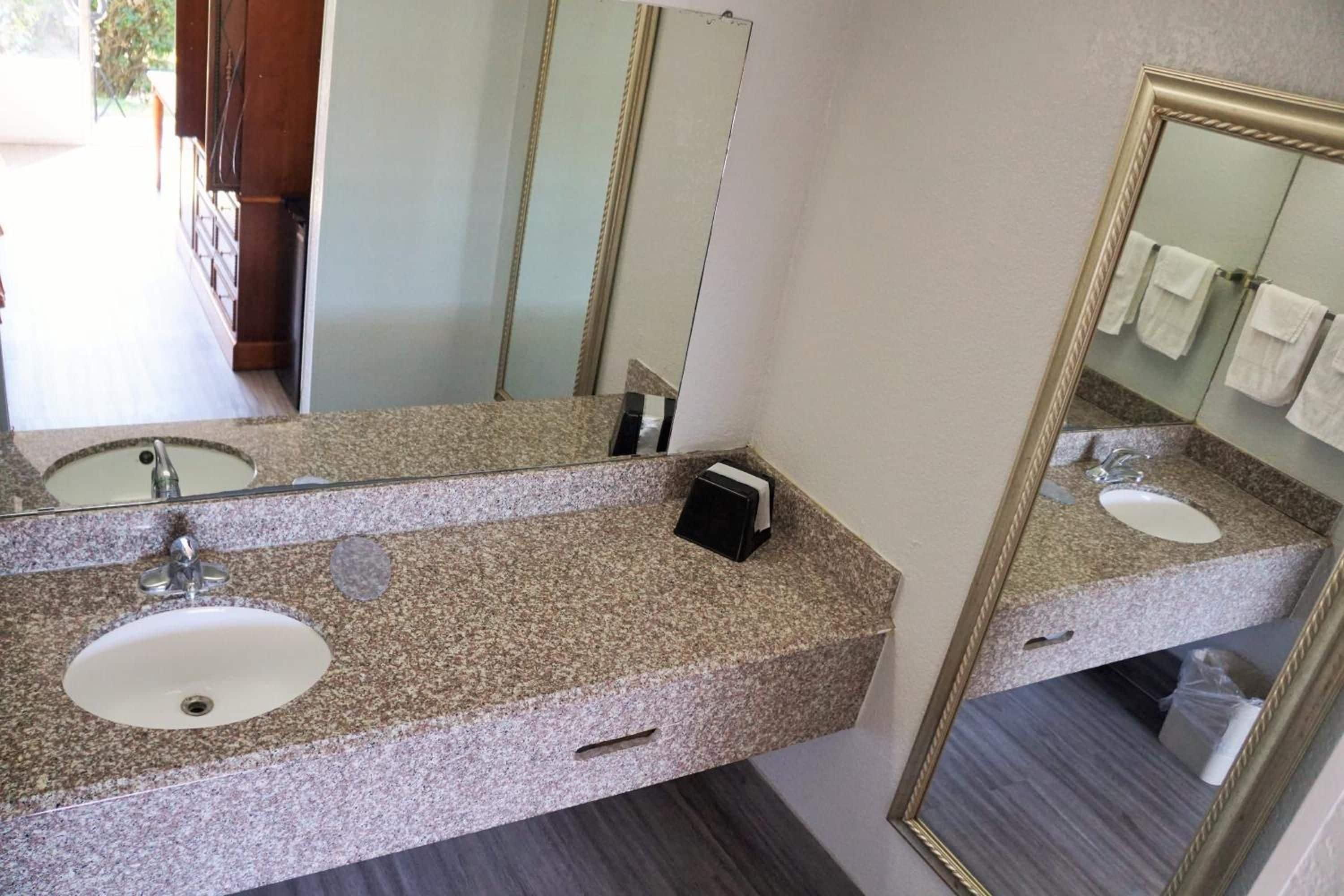 A bathroom with two sinks, a mirror, and a towel rack.