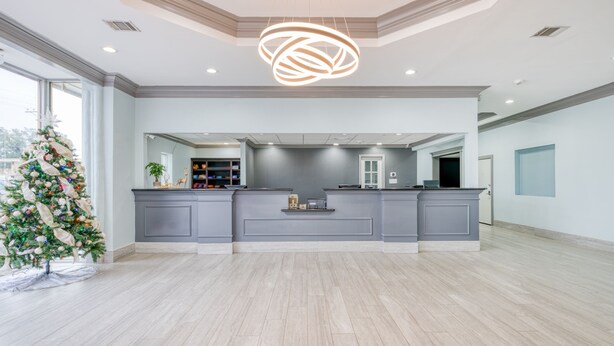 A spacious kitchen with a central island, grey cabinetry, and a modern pendant light. - Hotel elev8 (Conroe)