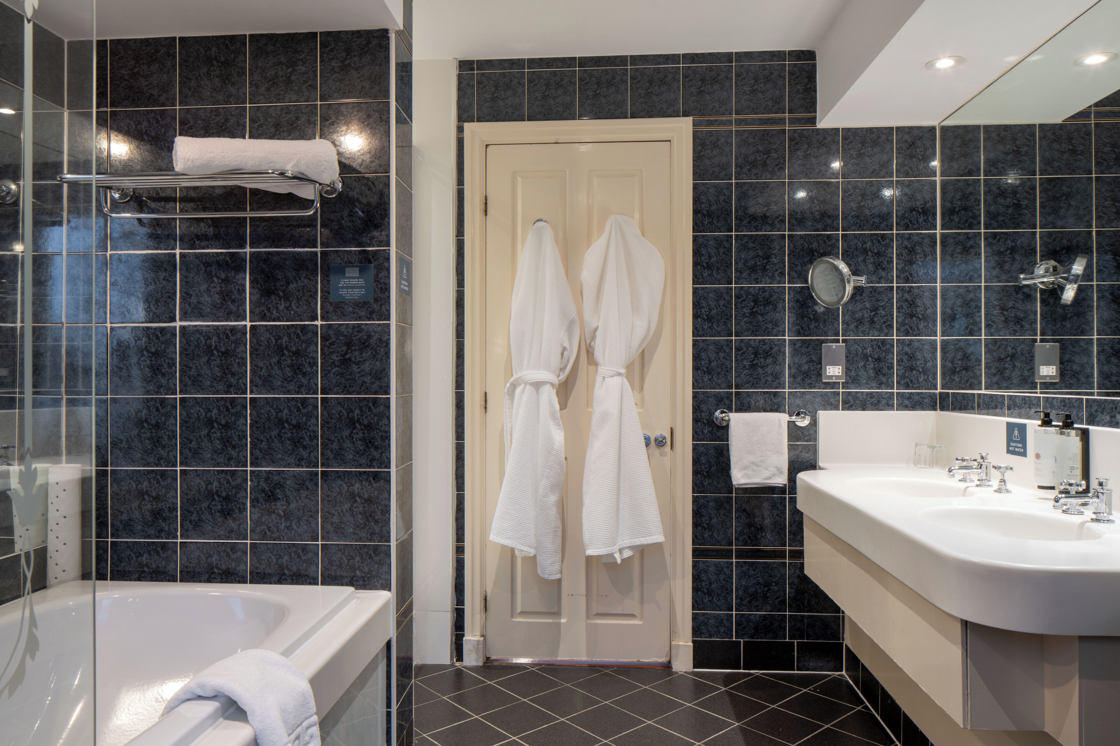 A modern bathroom with a bathtub, a shower, and a sink.