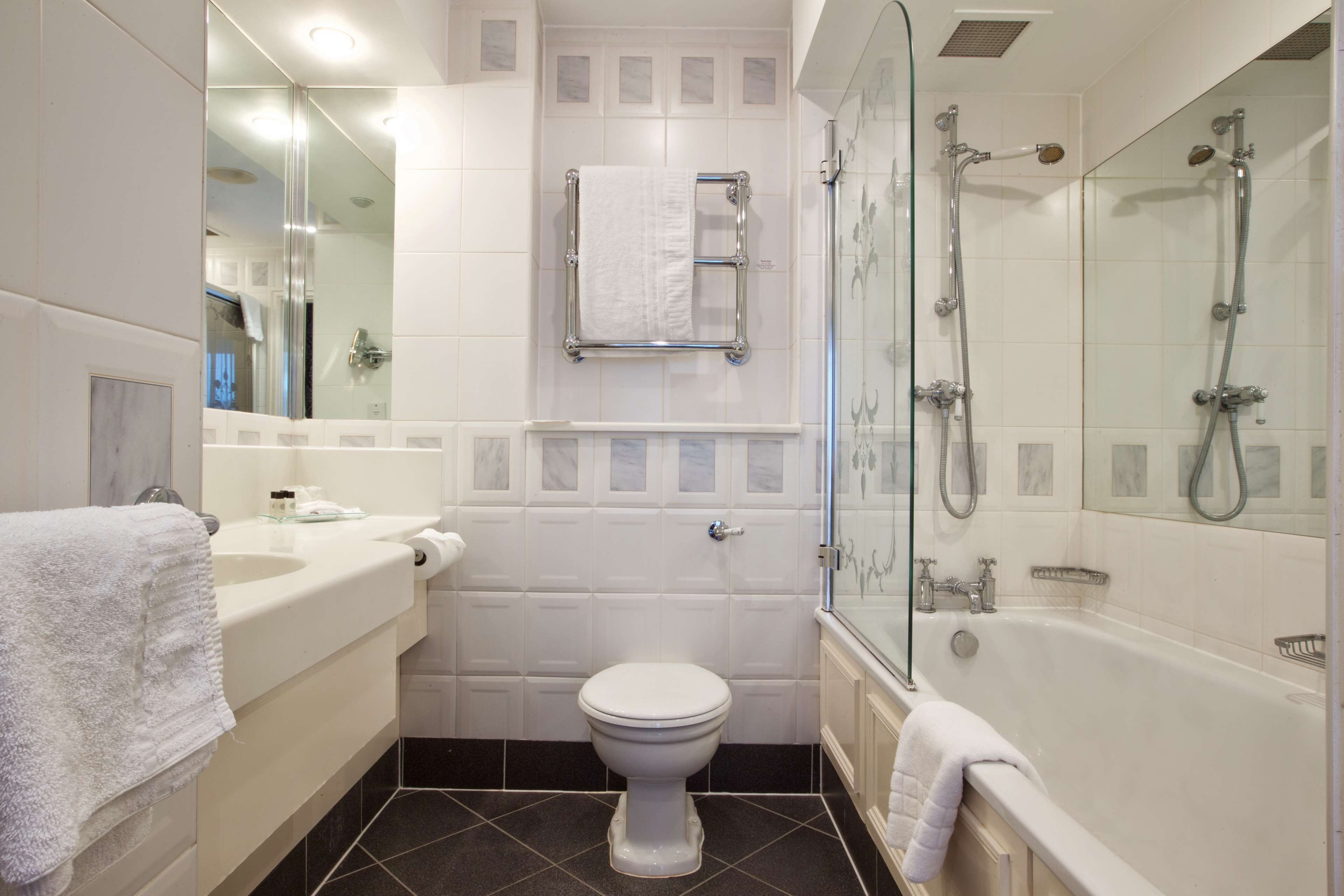 Een moderne badkamer met toilet, wastafel en bad.