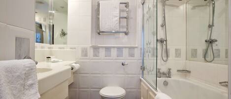 A modern bathroom with a toilet, sink, and bathtub.