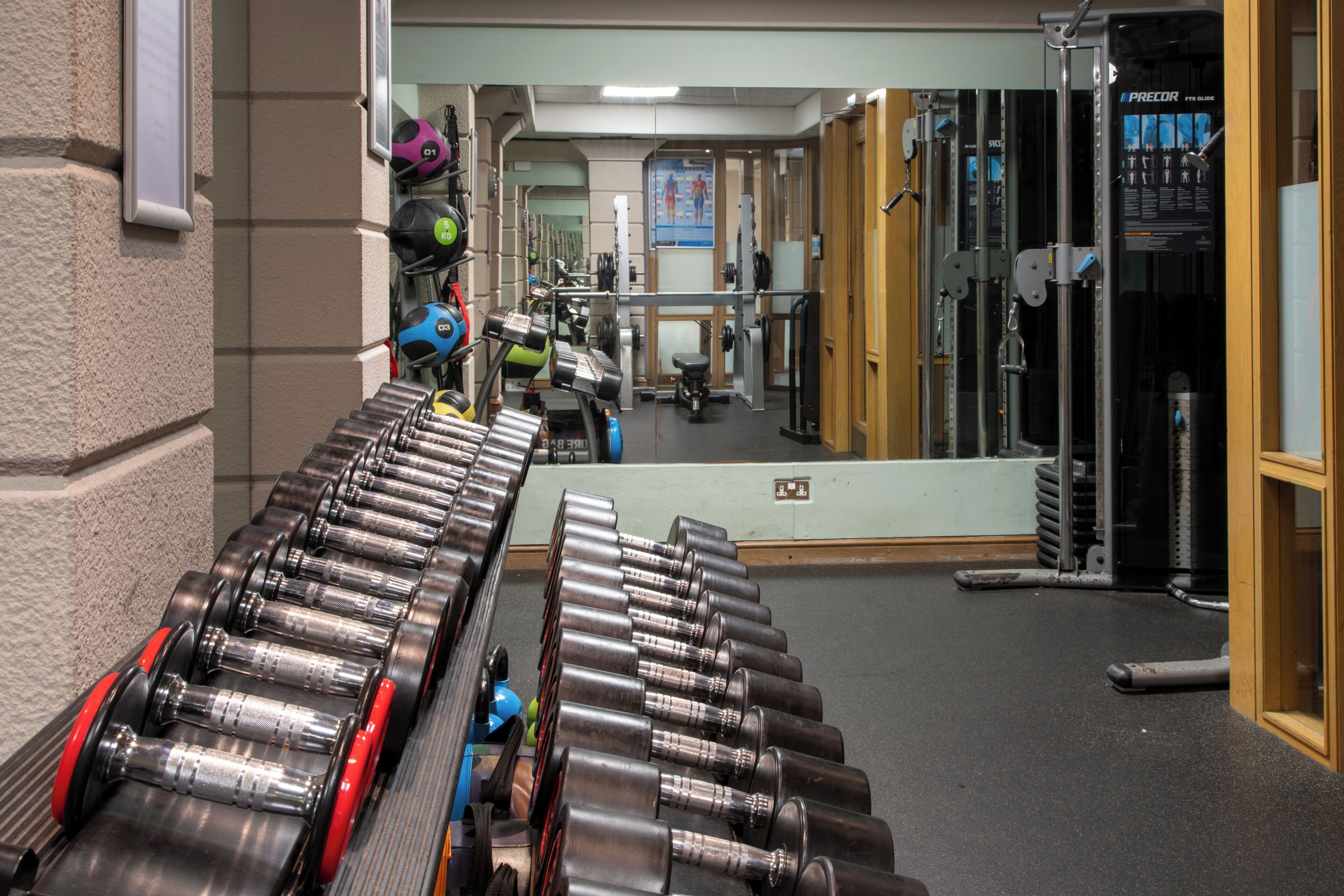 A gym with exercise equipment, including dumbbells and a treadmill.