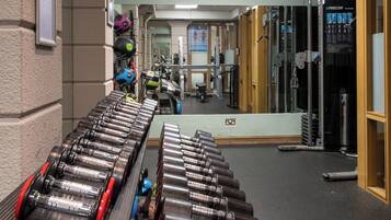A gym with exercise equipment, including dumbbells and a treadmill.