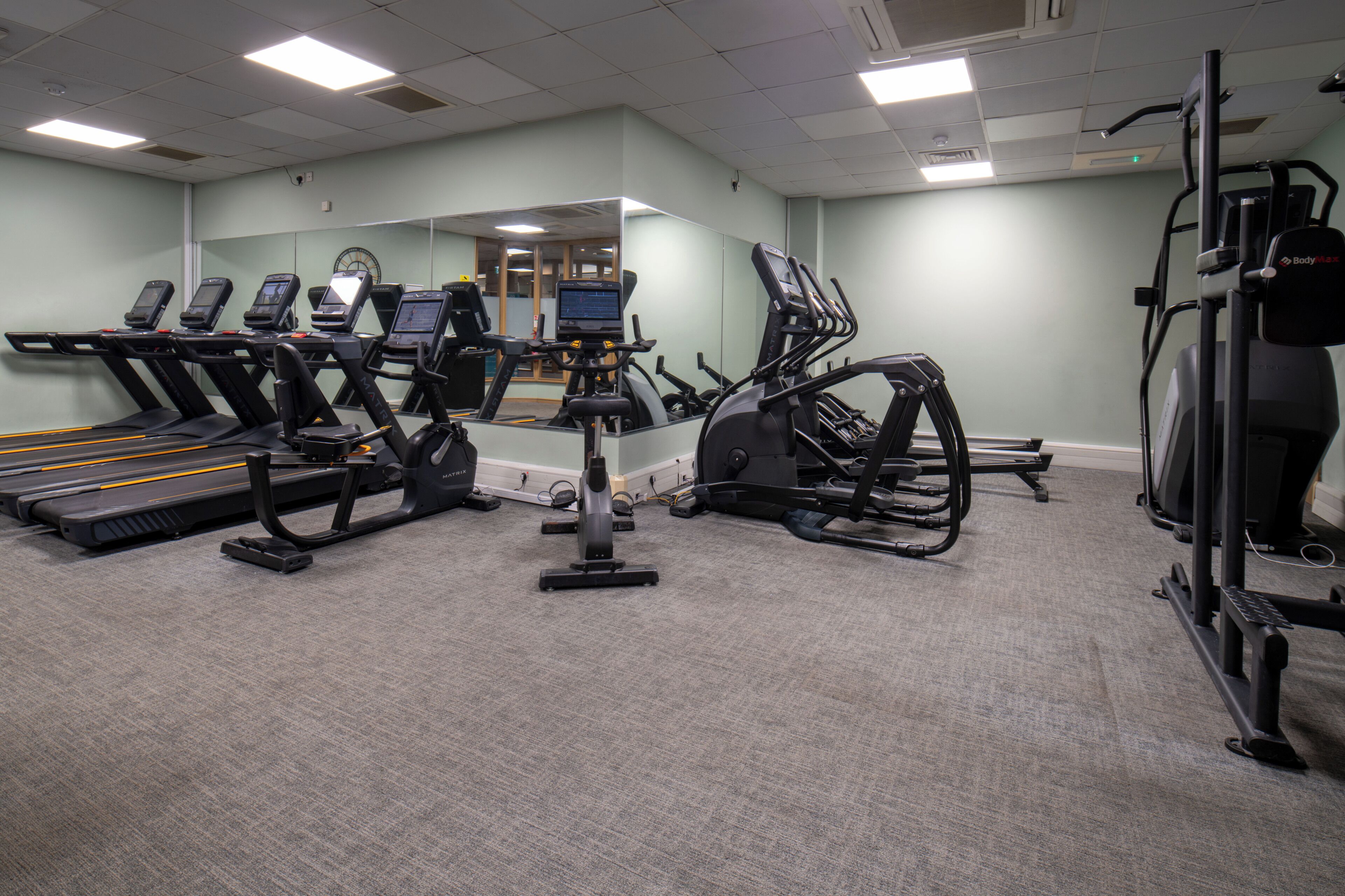 A fitness center with treadmills, elliptical machines, and a stationary bike.