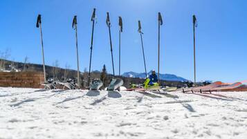 A ski slope with multiple ski poles and skis lined up.