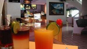 Una zona de bar con bebidas, un mostrador de recepción y un cuadro en la pared.