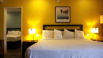 A hotel room with a large bed, two bedside lamps, and a framed picture on the wall.