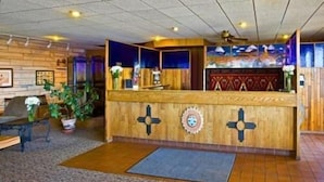 A reception area with a wooden counter, a ceiling fan, and a mural on the wall.