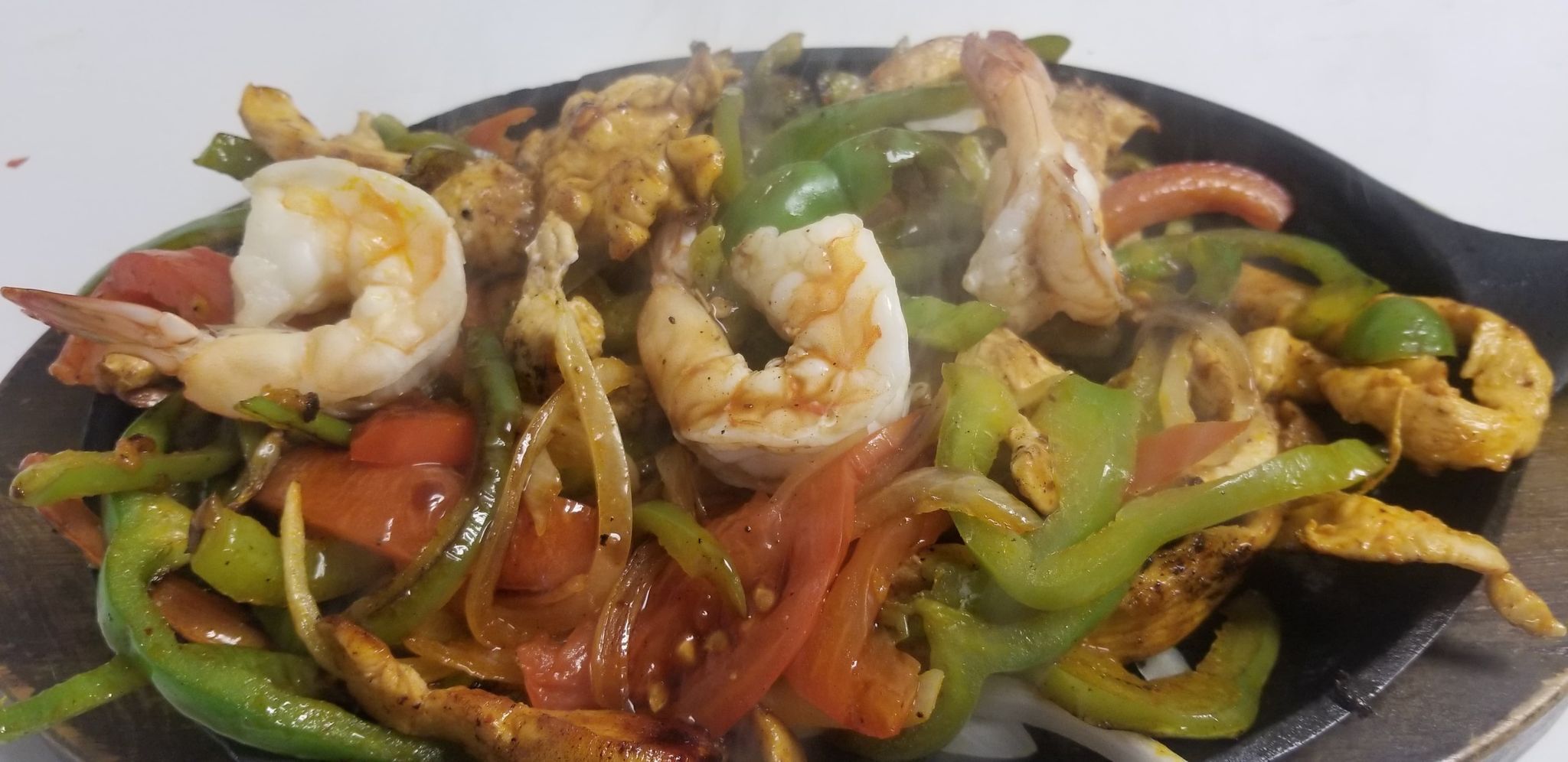 A stir-fried dish with shrimp, chicken, and vegetables.