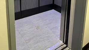 Un ascensor con barandilla metálica, el número 3 en la pared y un panel de pared texturizado.