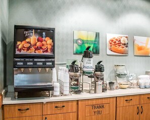 A juice dispenser with multiple options, a coffee machine, and a 'Thank You' sign on a counter.