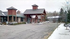 A building with a large entrance, stone pillars, and a covered area with a roof. - Quality Inn Rhinelander (Rhinelander)