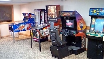 Una hilera de máquinas recreativas en una sala con alfombra estampada.