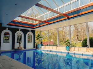 Una piscina techada, sillones reclinables de piscina