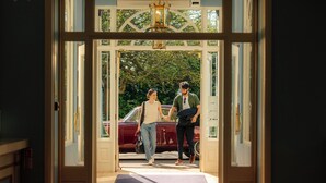 A hotel entrance with a red car parked outside, a doormat with a logo, and a chandelier above the door. - The Spa Hotel (Royal Tunbridge Wells)