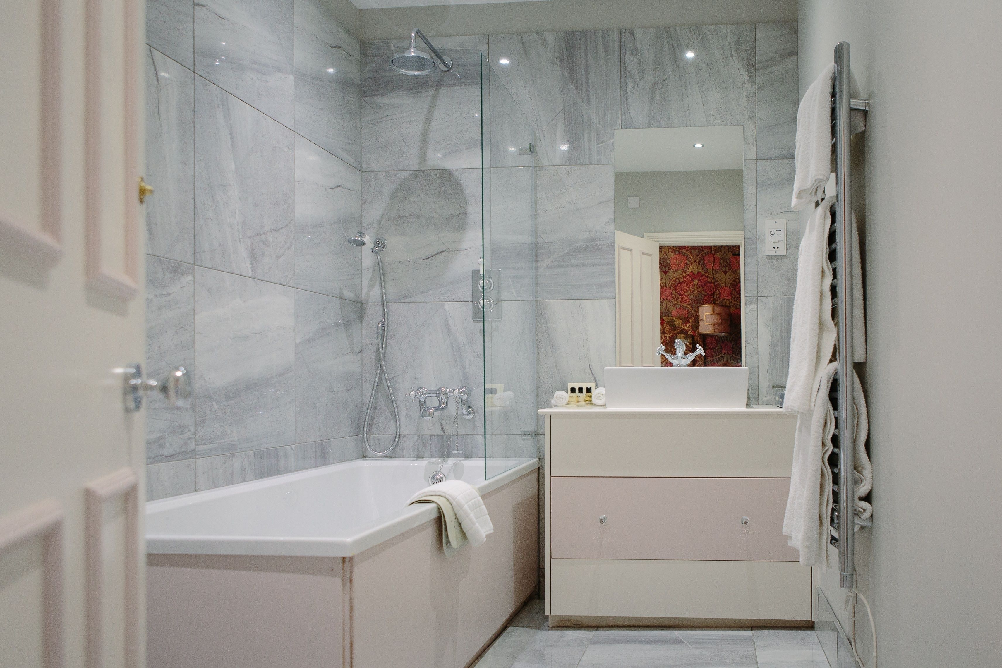 A modern bathroom with a bathtub, shower, and vanity.