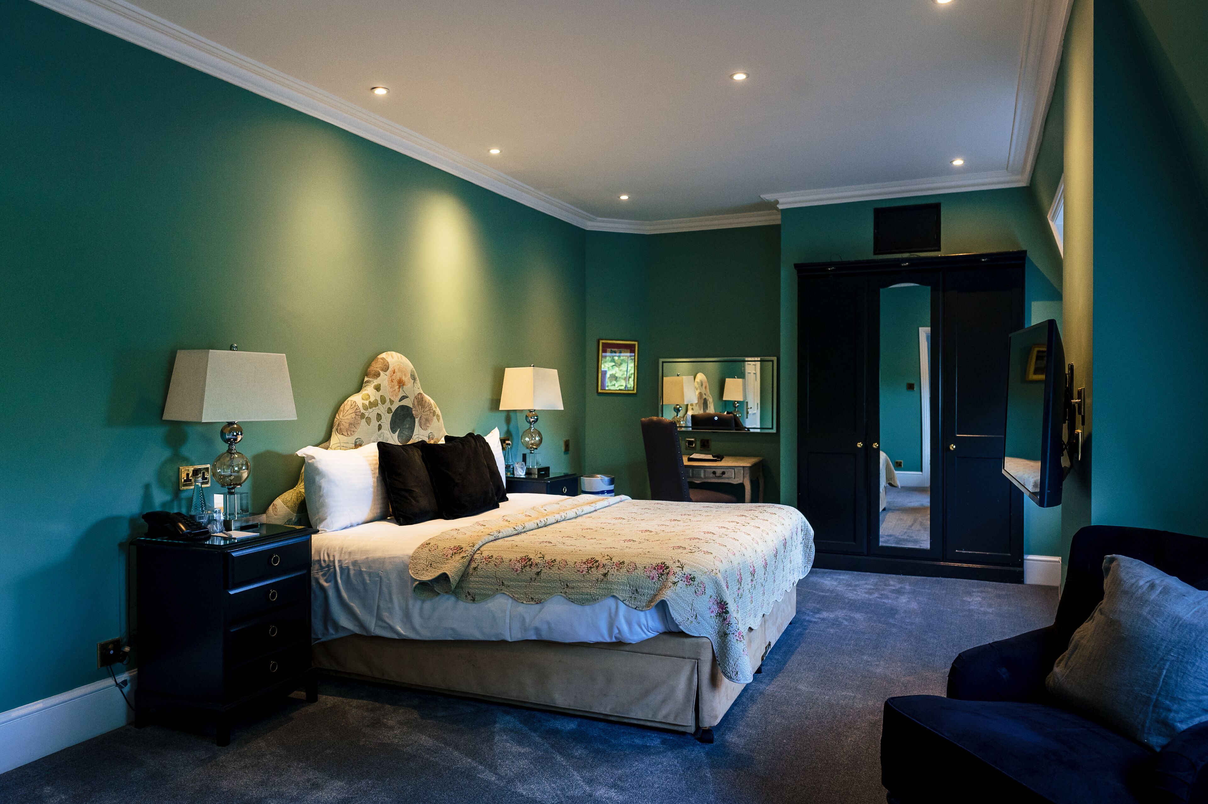 A bedroom with a bed, nightstands, a chair, and a dresser.