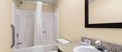 A bathroom with a bathtub, toilet, and sink.