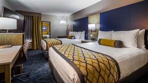 Quarto de hotel com duas camas, uma escrivaninha e uma cadeira.