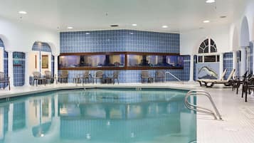 An indoor swimming pool with a tiled wall and multiple viewing windows.