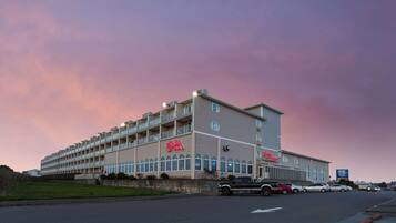 A multi-story hotel with a prominent 'Skilo' sign, featuring a row of windows and a flat roof.