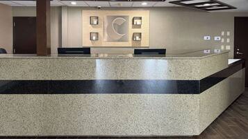 A reception desk with a large, abstract wall art piece above it.