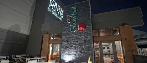 An outdoor seating area with a fire pit, tables, and chairs.
