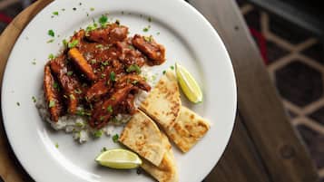 A plate of food with rice, meat, and flatbread, accompanied by a lime wedge.