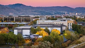 A modern building with a sign reading "FOUR POINTS BY SHERATON" surrounded by autumn foliage and mountains in the background. - Four Points by Sheraton Salt Lake City Airport (Salt Lake City)
