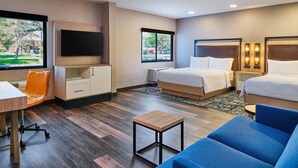 A hotel room with a bed, a desk, a chair, a TV, and a window with a view of a parking lot. - Four Points by Sheraton Salt Lake City Airport (Salt Lake City)