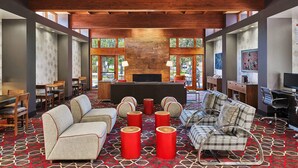 A spacious lobby with a high ceiling, wooden beams, a patterned carpet, and seating areas including sofas and chairs. - Four Points by Sheraton Salt Lake City Airport (Salt Lake City)