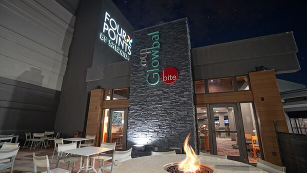 A restaurant with outdoor seating, a fire pit, and a sign for 'Four Points by Sheraton'. - Four Points by Sheraton Salt Lake City Airport (Salt Lake City)