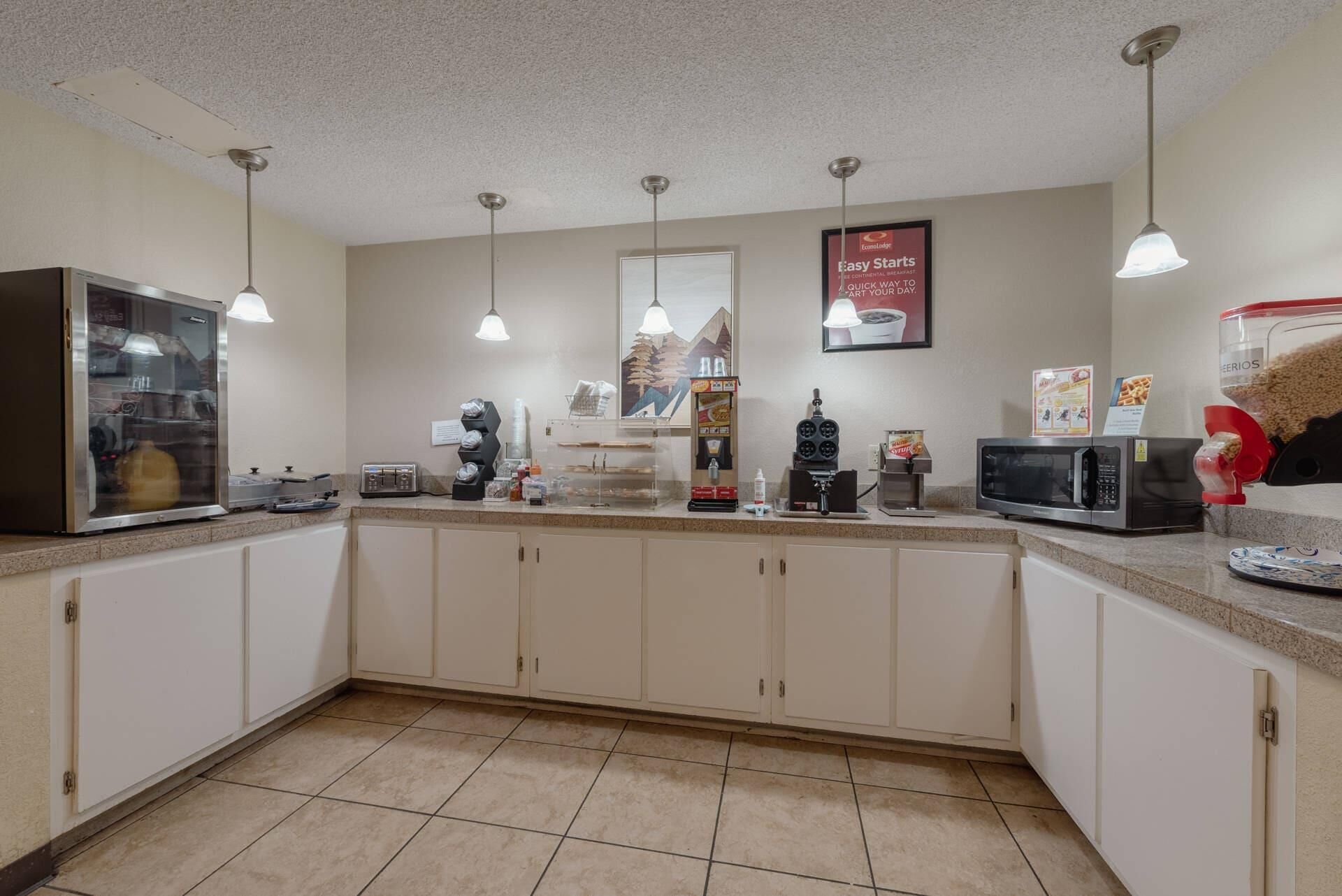Eine Küche mit Kaffeemaschine, Mikrowelle und Kühlschrank.