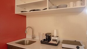 Une cuisine équipée d’un évier, d’une machine à café et d’un grille-pain.