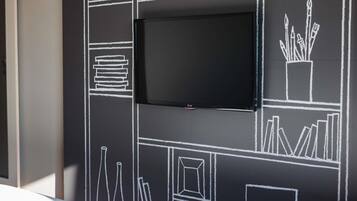 A blackboard with white chalk drawings of books, a clock, and a plant.