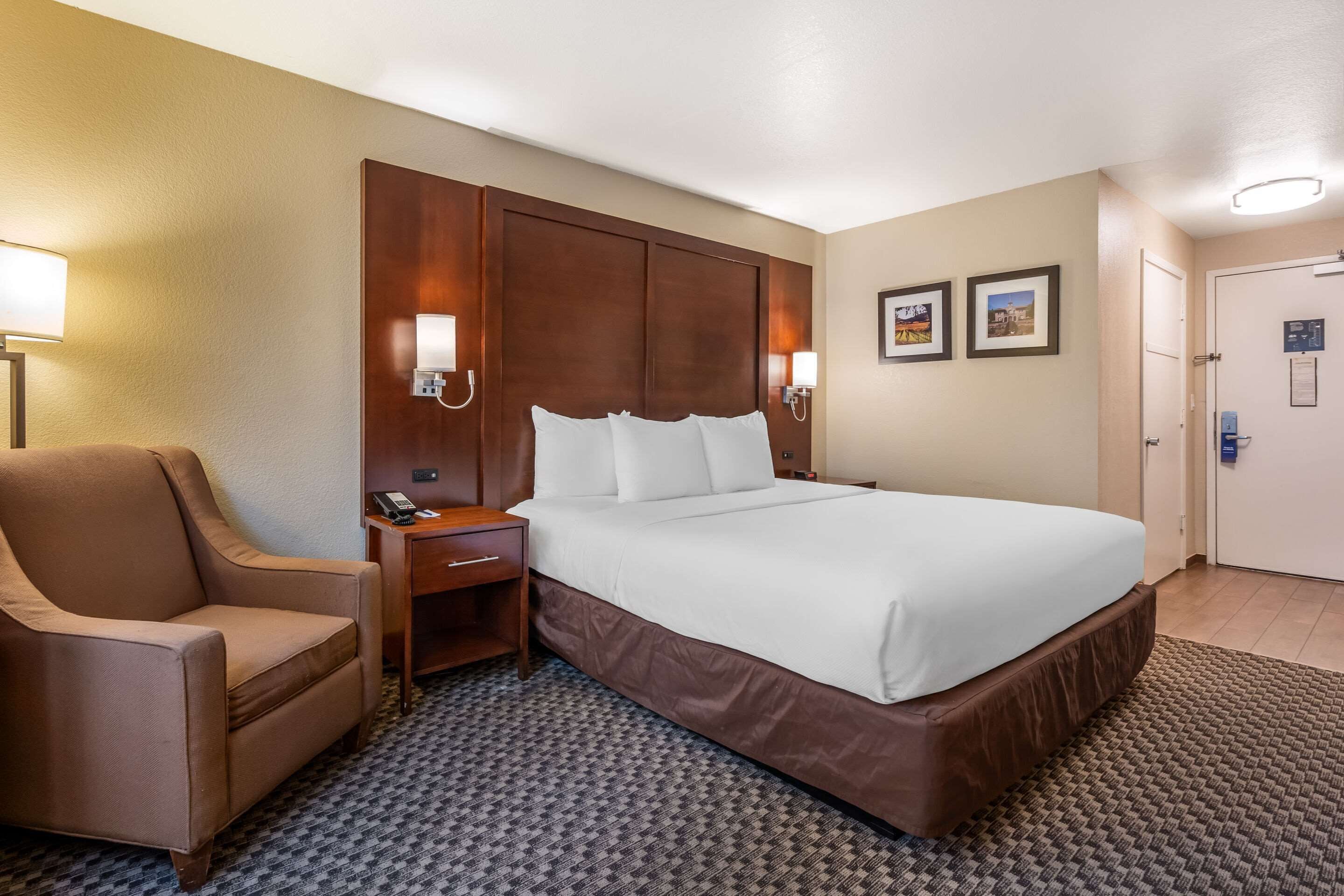 Escritorio, cortinas opacas, tabla de planchar con plancha