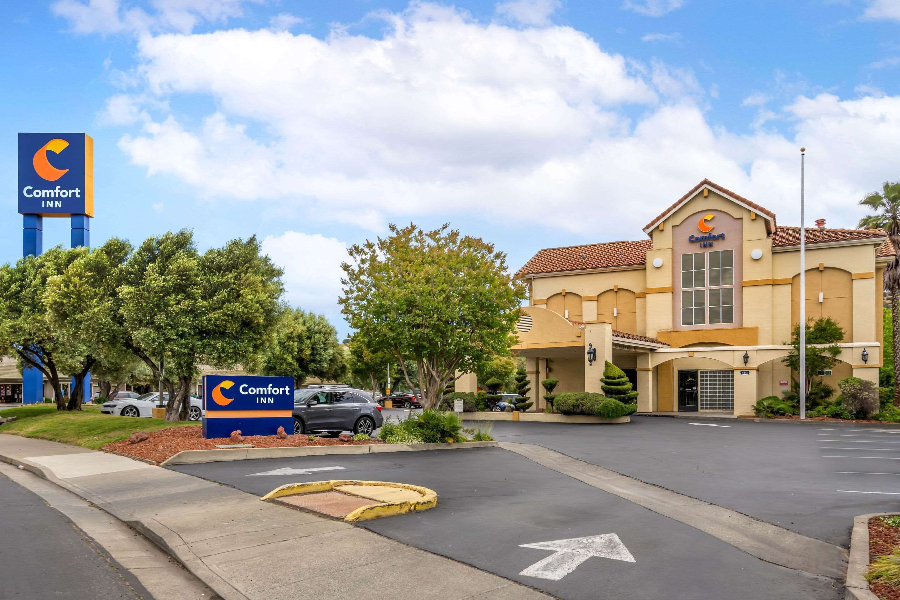 Un hôtel Comfort Inn doté d’une allée et d’un parking bien définis, entouré d’arbres et d’une pelouse bien entretenue.