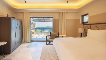 A hotel room with a large bed, a desk, a chair, a TV, and a view of the outdoors.