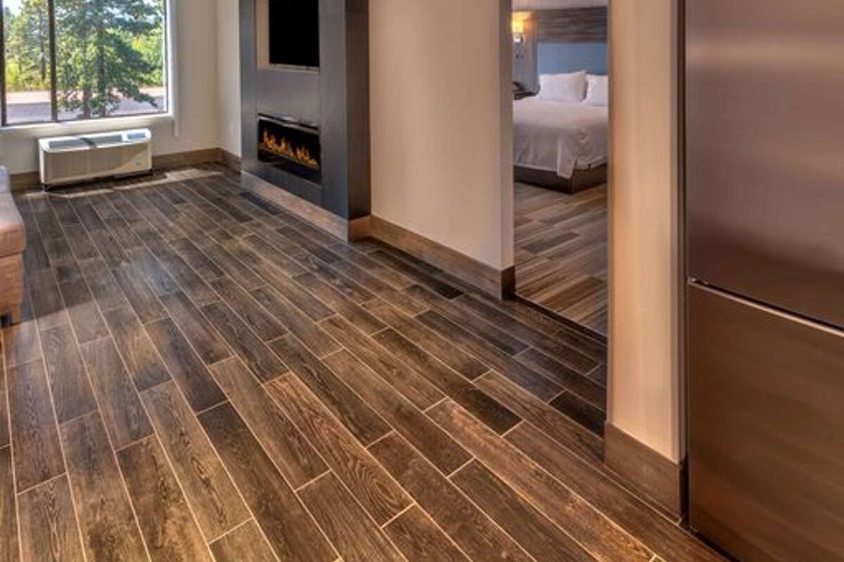 Una habitación de hotel moderna con un ventanal grande, una chimenea y una cama.