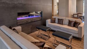 A modern living room with a sofa, a coffee table, and a built-in fireplace.
